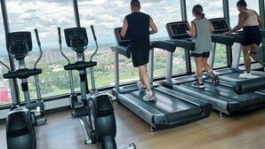 A gym with treadmills and elliptical machines, large windows with a city view. - Sky pool Holiday home near Tha Phae Gate Old town 2 bedroom (Chang Wat Chiang Mai)