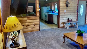 Ein Blockhaus-Interieur mit Essbereich, Küche und Wohnzimmer.