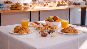A breakfast buffet with croissants, fruits, and juices on a table. - Hotel Four Islands (Ksamil)