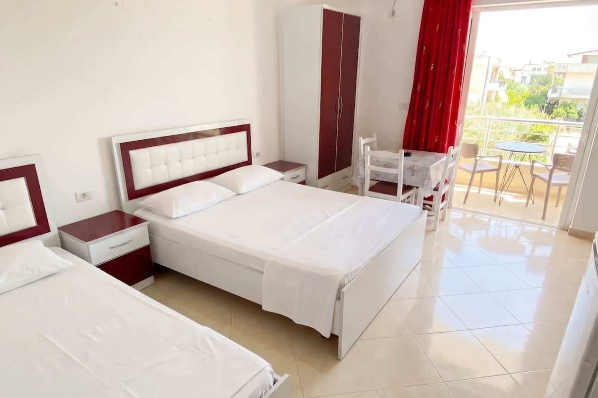 A hotel room with a bed, a desk, a chair, and a wardrobe.