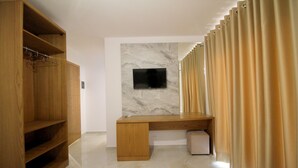 A modern bathroom with a wooden vanity, a marble wall, and a flat-screen TV. - Hotel Four Islands (Ksamil)
