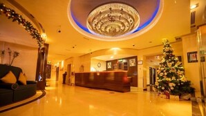 A lobby with a reception desk, a Christmas tree, and a large circular light fixture on the ceiling. - Three Bedroom Apartment In Sadaf 3 Jbr By E R (Dubai)