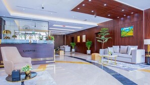 A modern reception area with a reception desk, seating arrangements, and decorative plants.