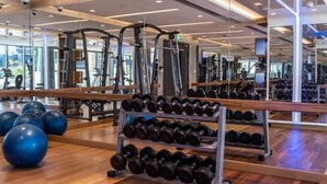 Ett gym med träningsutrustning, ett ställ med hantlar och träningsbollar.