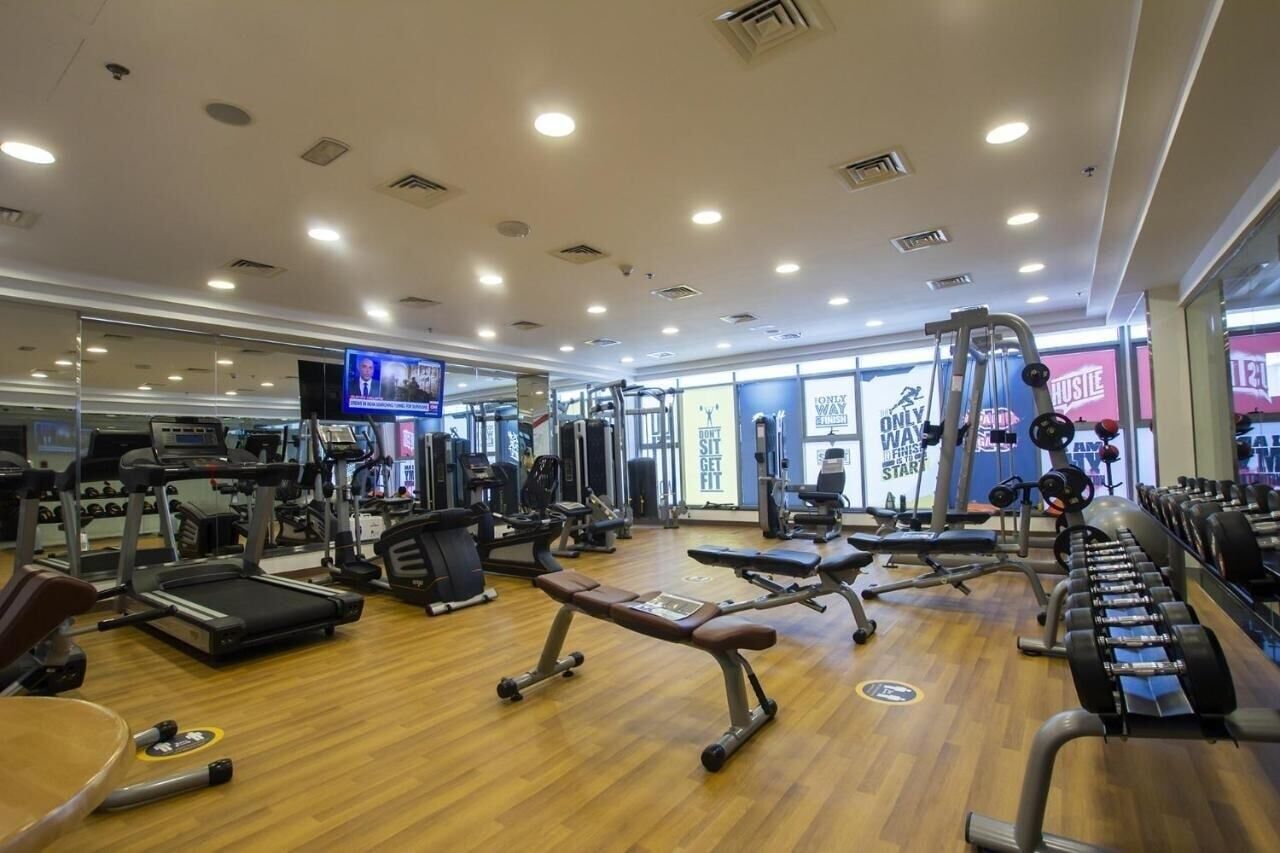 A gym with treadmills, weight benches, and various exercise machines.