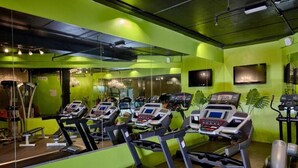 A gym with multiple treadmills, mirrors, and exercise equipment. - Studio Apartment In Discovery Gardens By E R (Dubai)