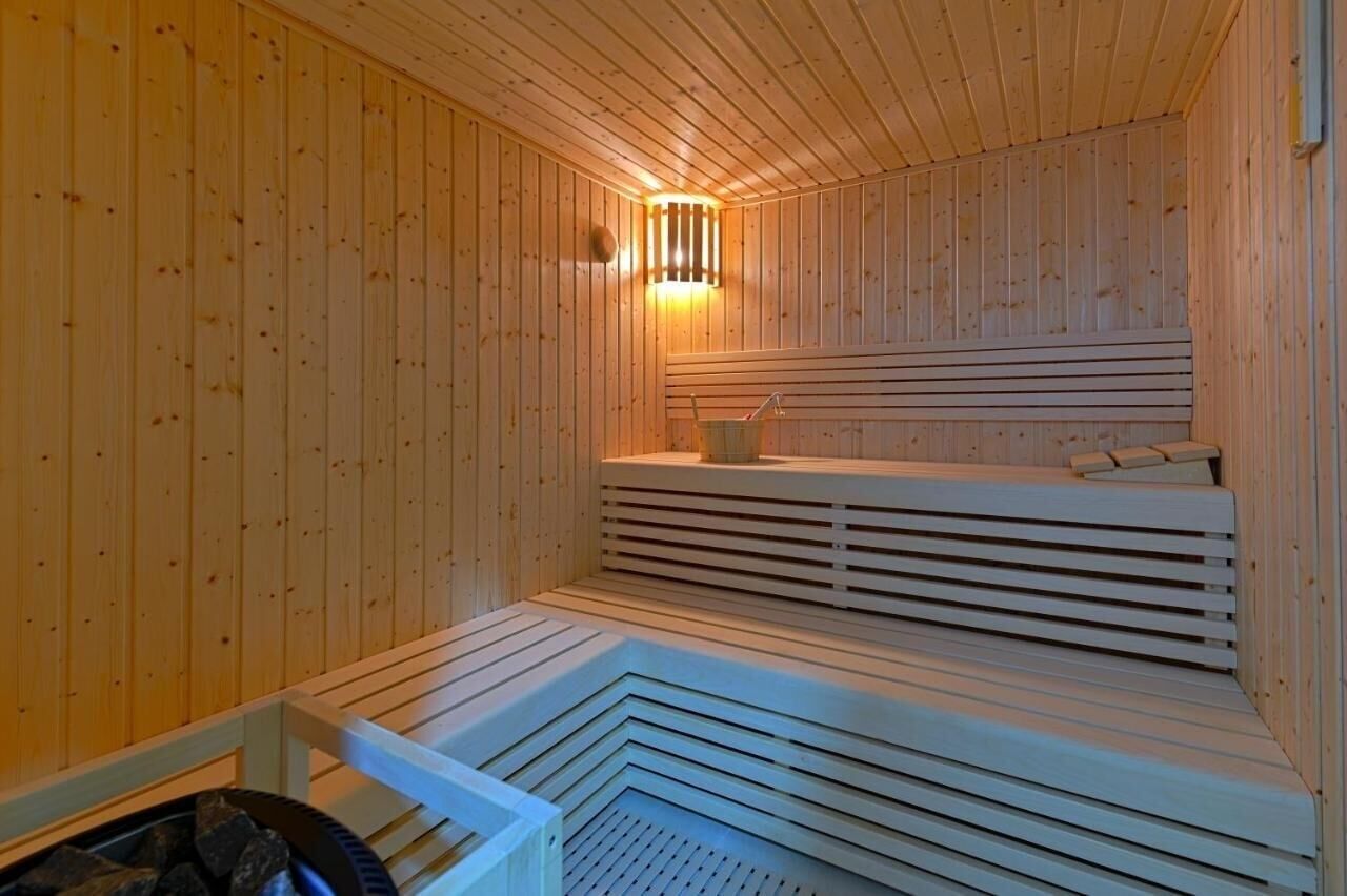 Un sauna avec des murs et des bancs en bois, un banc avec une serviette et une petite table avec une serviette.