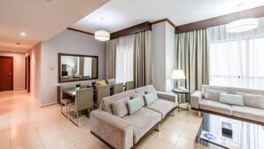 Ein modernes Wohnzimmer mit einer Couch, einem Couchtisch und einem Essbereich mit Stühlen und einem Tisch.