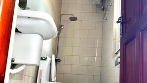 A bathroom with a toilet, shower, and a purple door. - Apartment - Sleeps 2 - Parking - Garden (Kampala)
