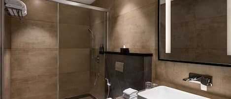 A modern bathroom with a glass-enclosed shower, a white sink, and a large mirror.