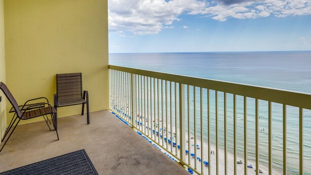 A balcony with a view of the ocean, two chairs, and a railing. - Balcony & Beach Access: Oceanfront PCB Condo (Panama City)