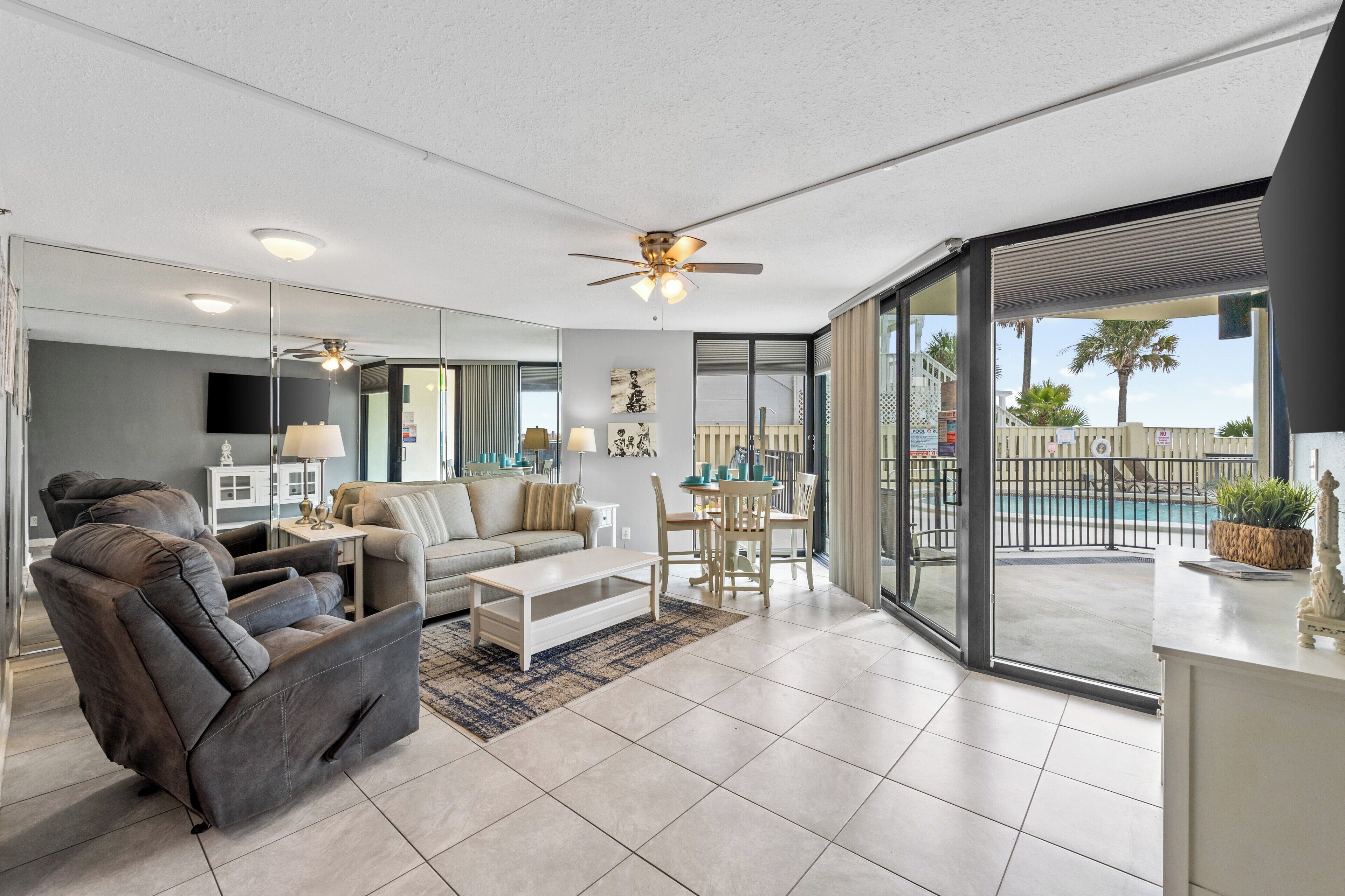 A modern living room with a sofa, recliner, coffee table, and dining area.