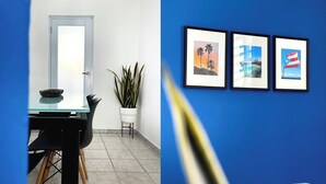 Un comedor moderno con una mesa de vidrio, sillas y una planta en maceta.
