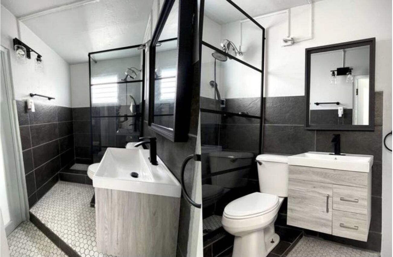 A modern bathroom with a shower, toilet, and sink.