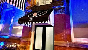 A building facade with a large illuminated sign displaying the number 211.