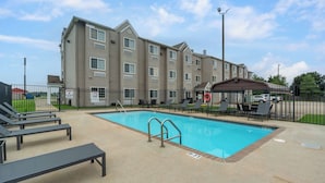 A hotel with a swimming pool, lounge chairs, and a covered patio area. - Motel 6 Breaux Bridge, La (Breaux Bridge)
