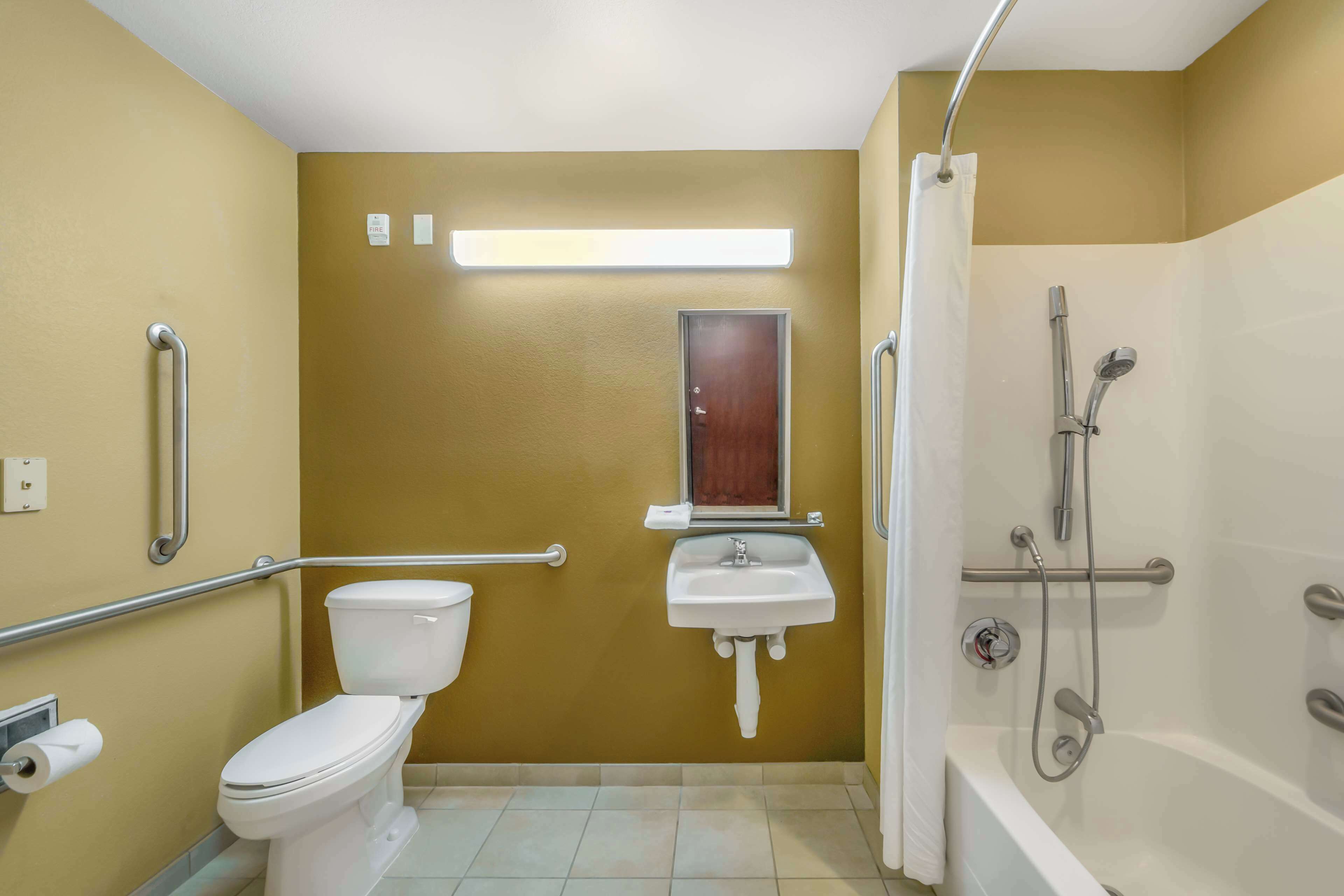 Une salle de bain avec des toilettes, un lavabo et une douche.