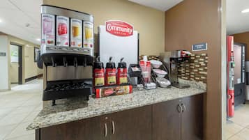 A coffee station with branded dispensers and a sign for 'Community Coffee'.