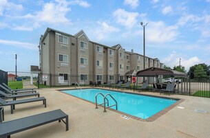 Um hotel com piscina, espreguiçadeiras e um espaço coberto com terraço.
