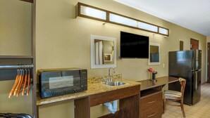 A compact kitchen with a microwave, sink, and refrigerator. - Studio 6 Suites - Breaux Bridge, La (Breaux Bridge)