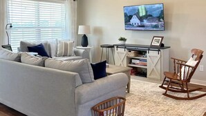 A living room with a sofa, a wooden rocking chair, a TV, and a ceiling fan. - The Red Gate - Branson & Eureka!
 (Green Forest)