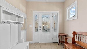 A hallway with a white door with glass panels, a small round table, and a wooden bench. - ⭐️ Brand New, Fully Renovated Home Steps to Boardwalk Beach (Ocean City)