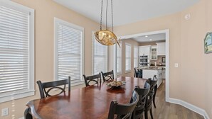 A dining area with a wooden table, chairs, and a hanging light fixture. - ⭐️ Brand New, Fully Renovated Home Steps to Boardwalk Beach (Ocean City)