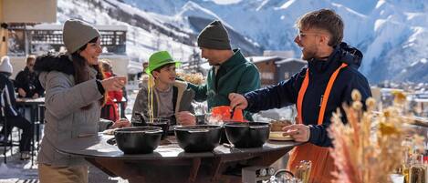 Un grupo de personas en un puesto de comida con un telón de fondo montañoso.