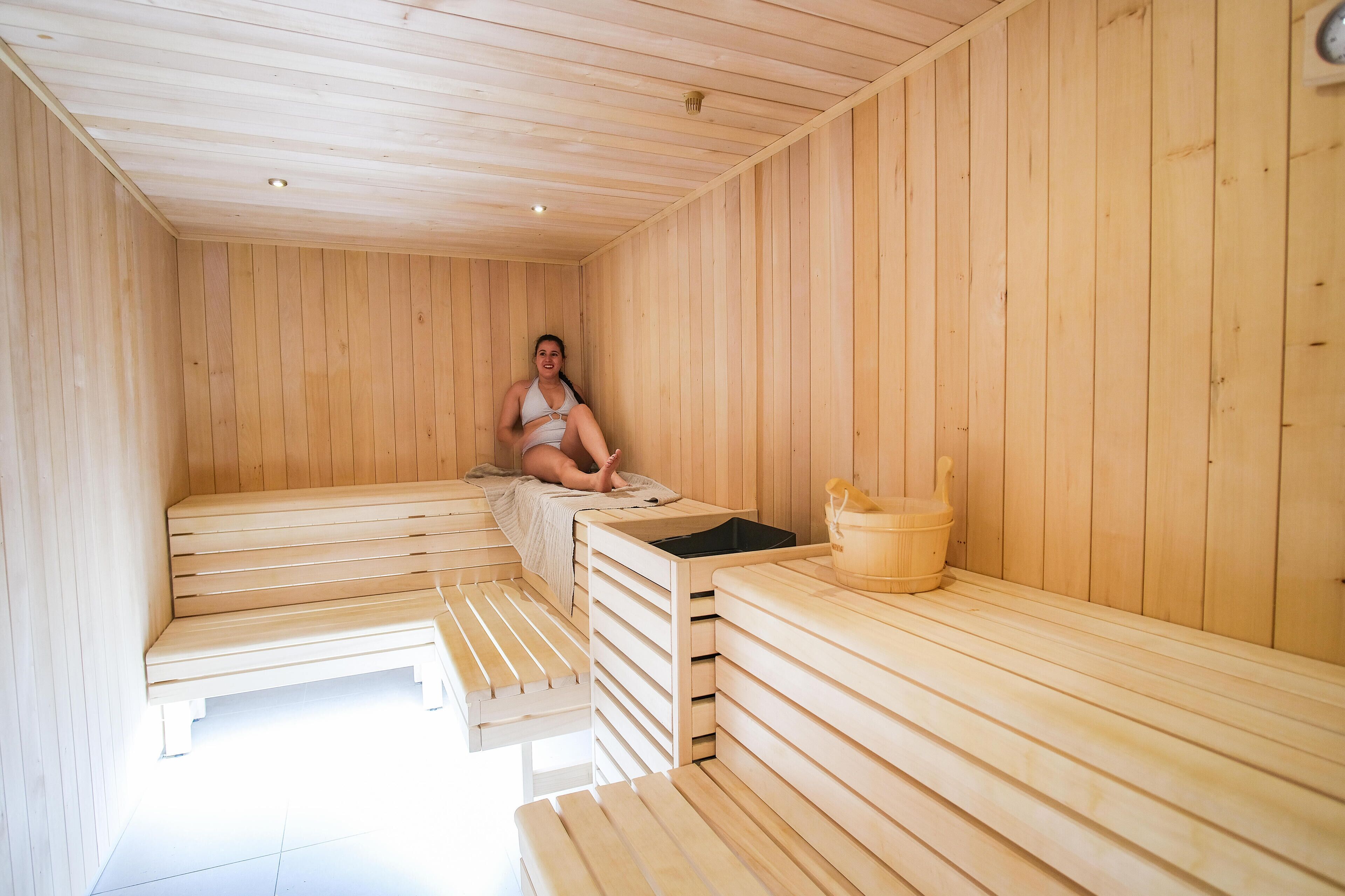 A sauna room with wooden benches and a bench seat.