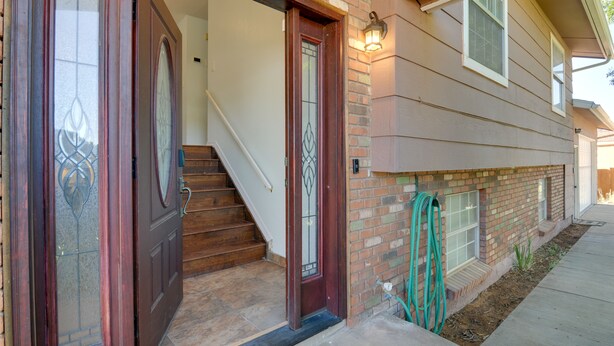 A two-story house with a front door, a staircase, and a small garden area.