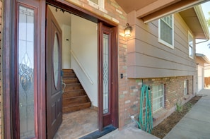 Traditional two-story building with a brick facade and a flat roof, featuring a front door with a glass panel and decorative design.