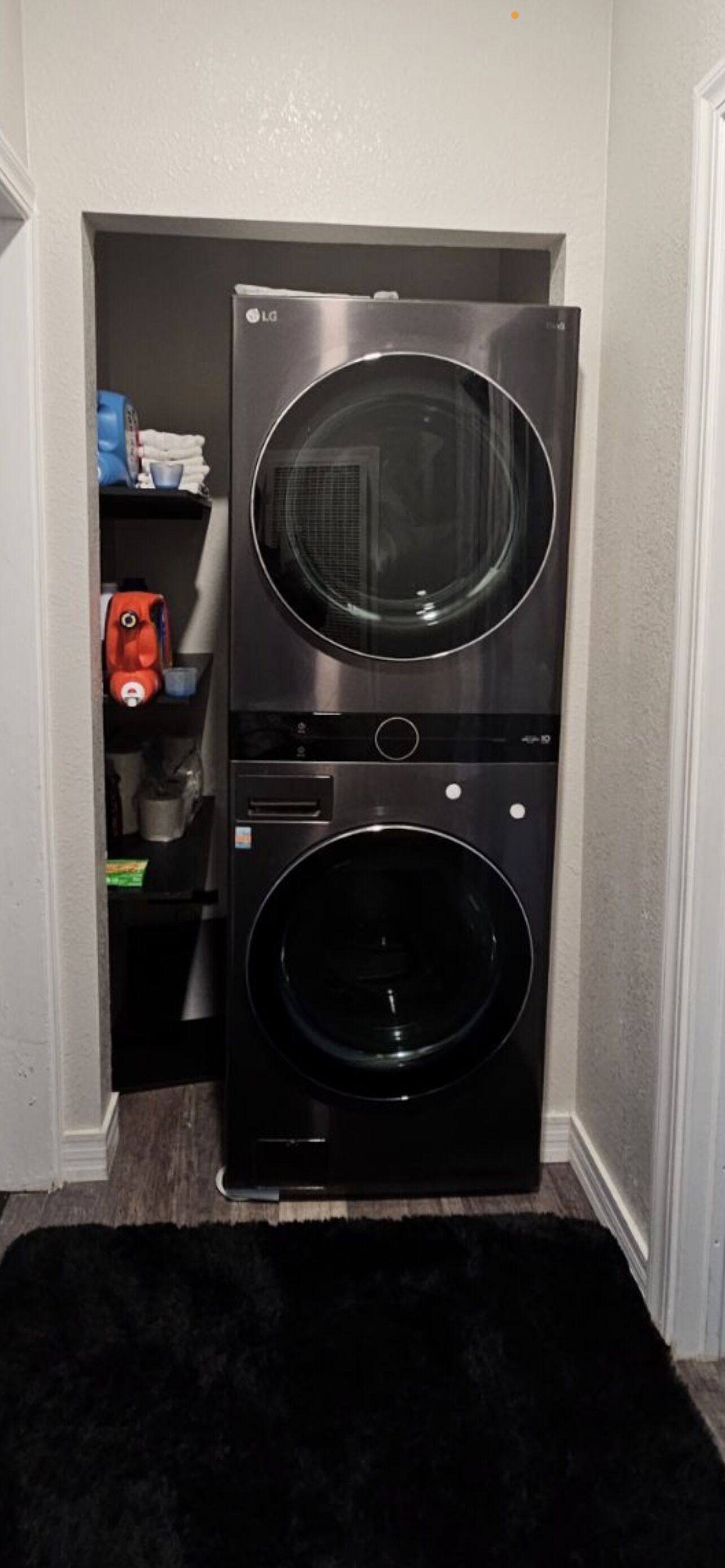 A stacked washer and dryer unit in a laundry room.