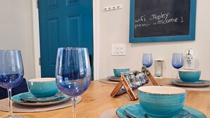 Eine Küchenarbeitsplatte mit blauem Glas und passendem Geschirr, eine Kreidetafel mit der Aufschrift 'Thank you for visiting' und eine blaue Tür.