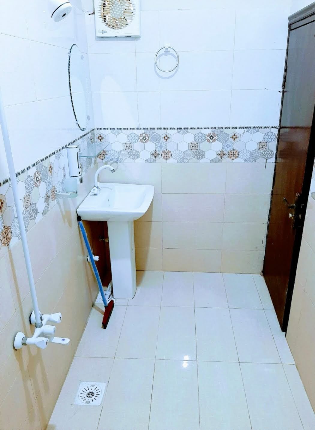 Une petite salle de bain avec un lavabo blanc, des toilettes et une douche.