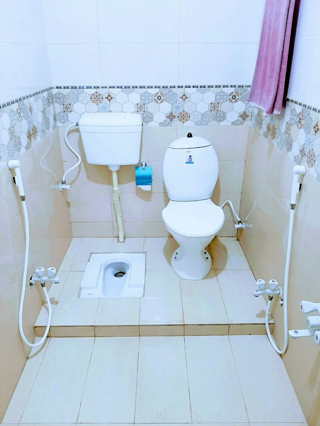 Een kleine badkamer met tegels, voorzien van toilet, bidet en douche.