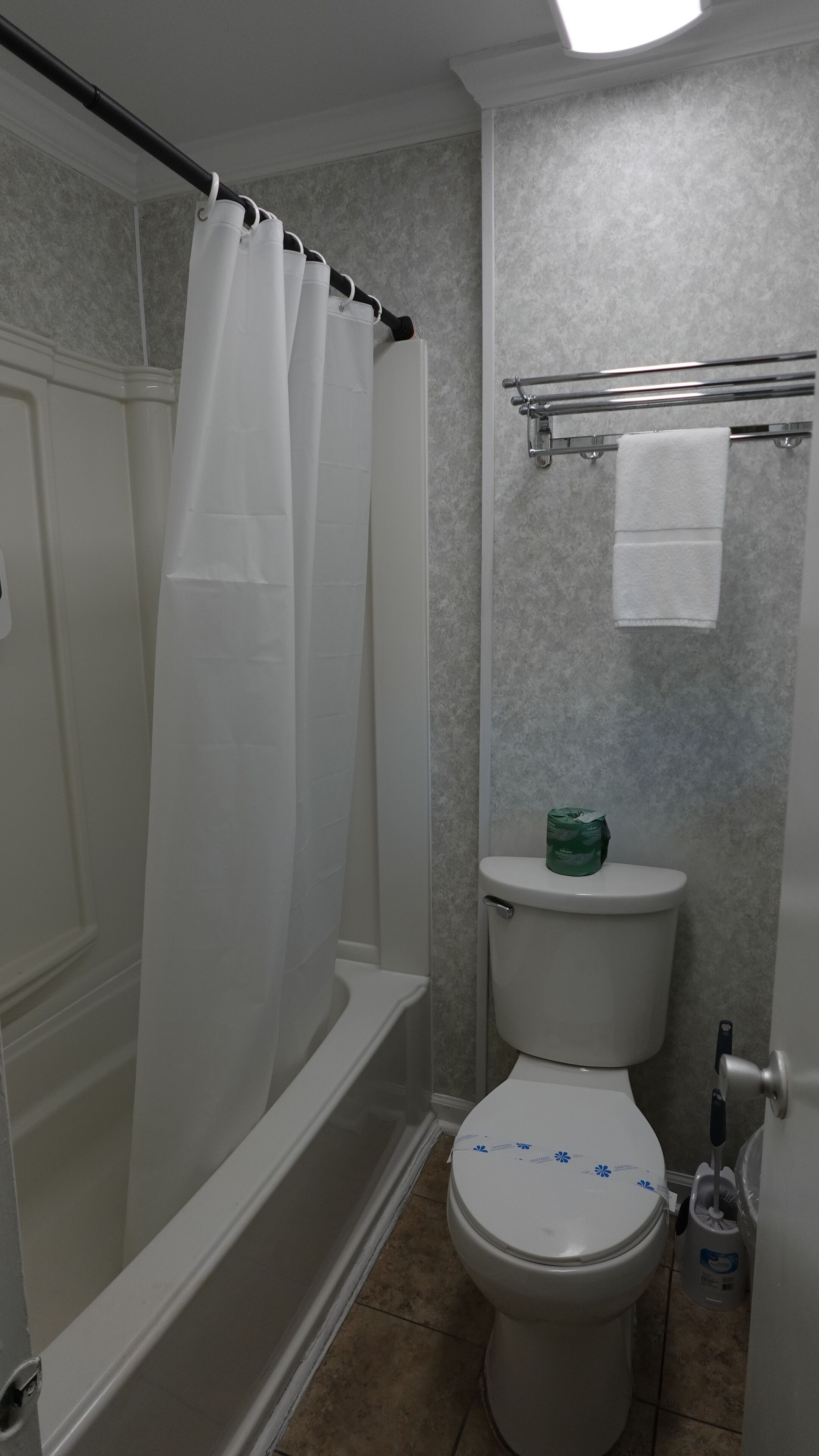 Un baño con bañera, inodoro y cortina de ducha.