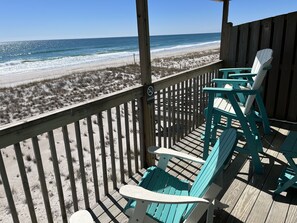A wooden deck with turquoise chairs overlooking a beach. - Sea Vista Motel (Holly Ridge)