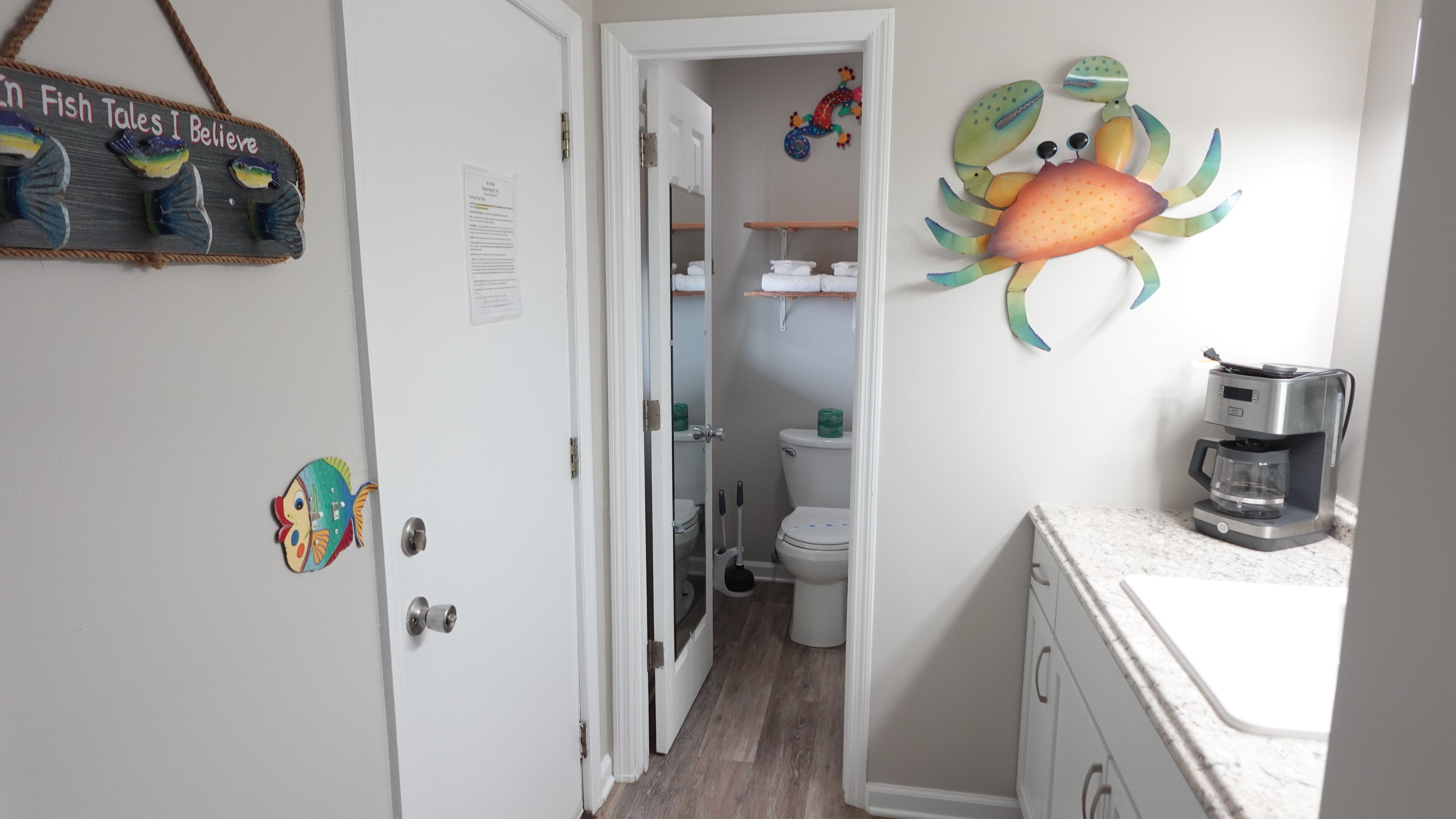 A bathroom with a toilet, a sink, and a coffee maker.