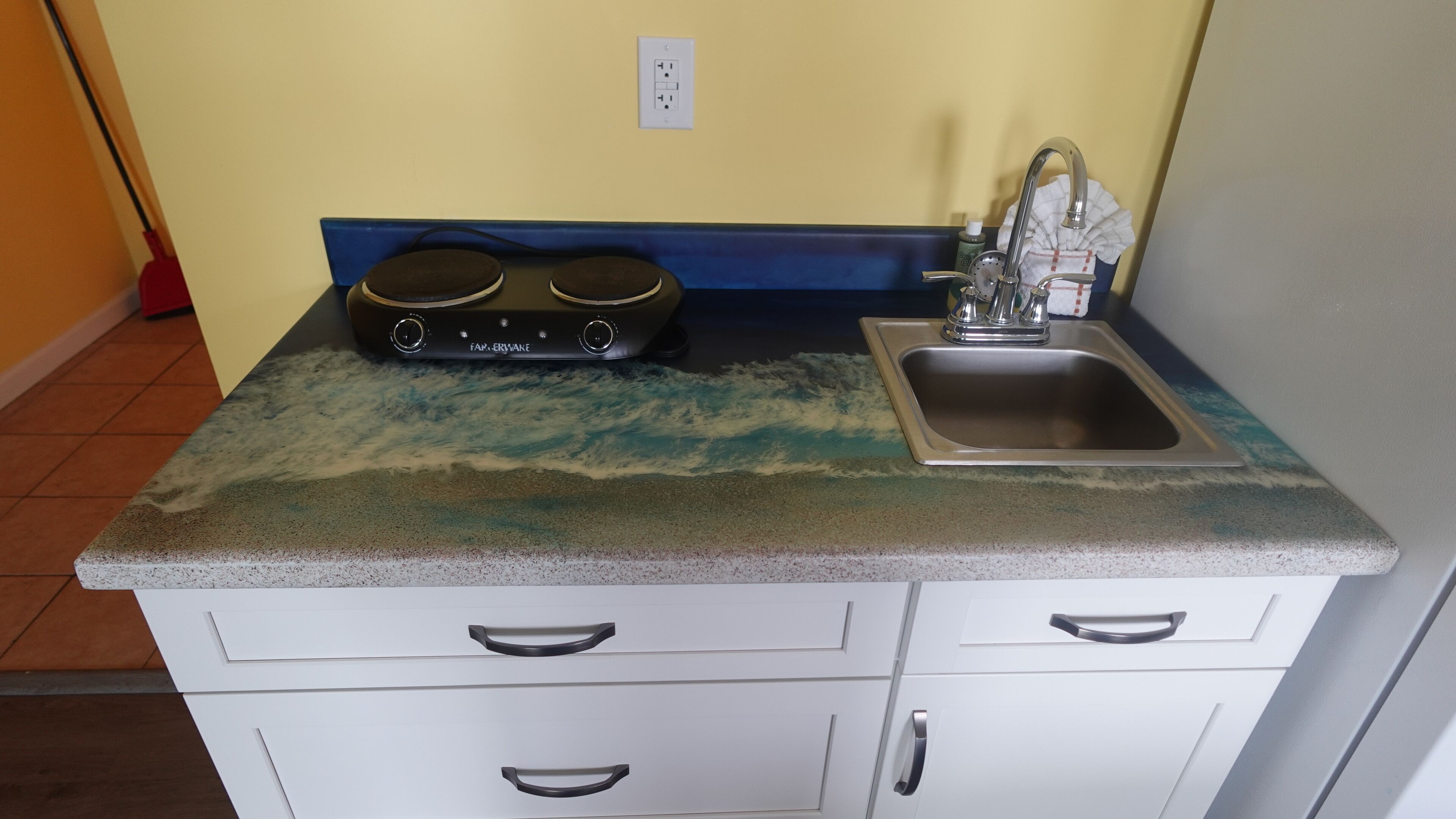 A kitchen with a granite countertop, a sink, and a stove.
