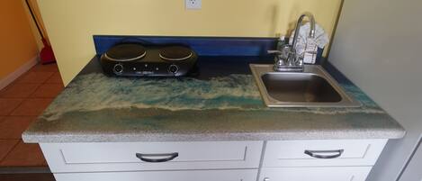 A kitchen with a granite countertop, a sink, and a stove.