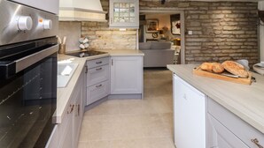 Una cocina moderna con horno empotrado, estufa y una encimera con pan.
