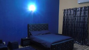 A bedroom with a bed, nightstand, and a blue rug.