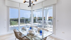 A modern dining area with a glass table, chairs, and a view of the outdoors. - Homity Exclusive Ab-3-c6-2d (Motril)
