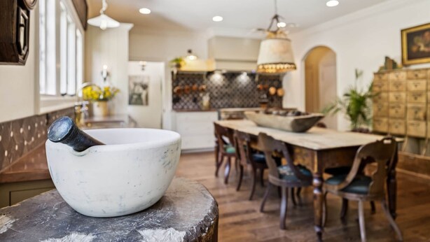 A dining area with a large table, chairs, and a stone bowl on a counter. - Historic Leiper's Fork Inn (Williamson County)