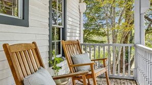 A porch with two wooden rocking chairs, a white railing, and a ceiling fan. - Historic Leiper's Fork Inn (Williamson County)