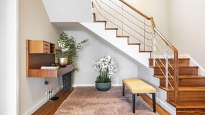 A staircase with wooden steps and metal railings, a bench, and a potted plant. - Casa Olimpo by Homie (Camara de Lobos)