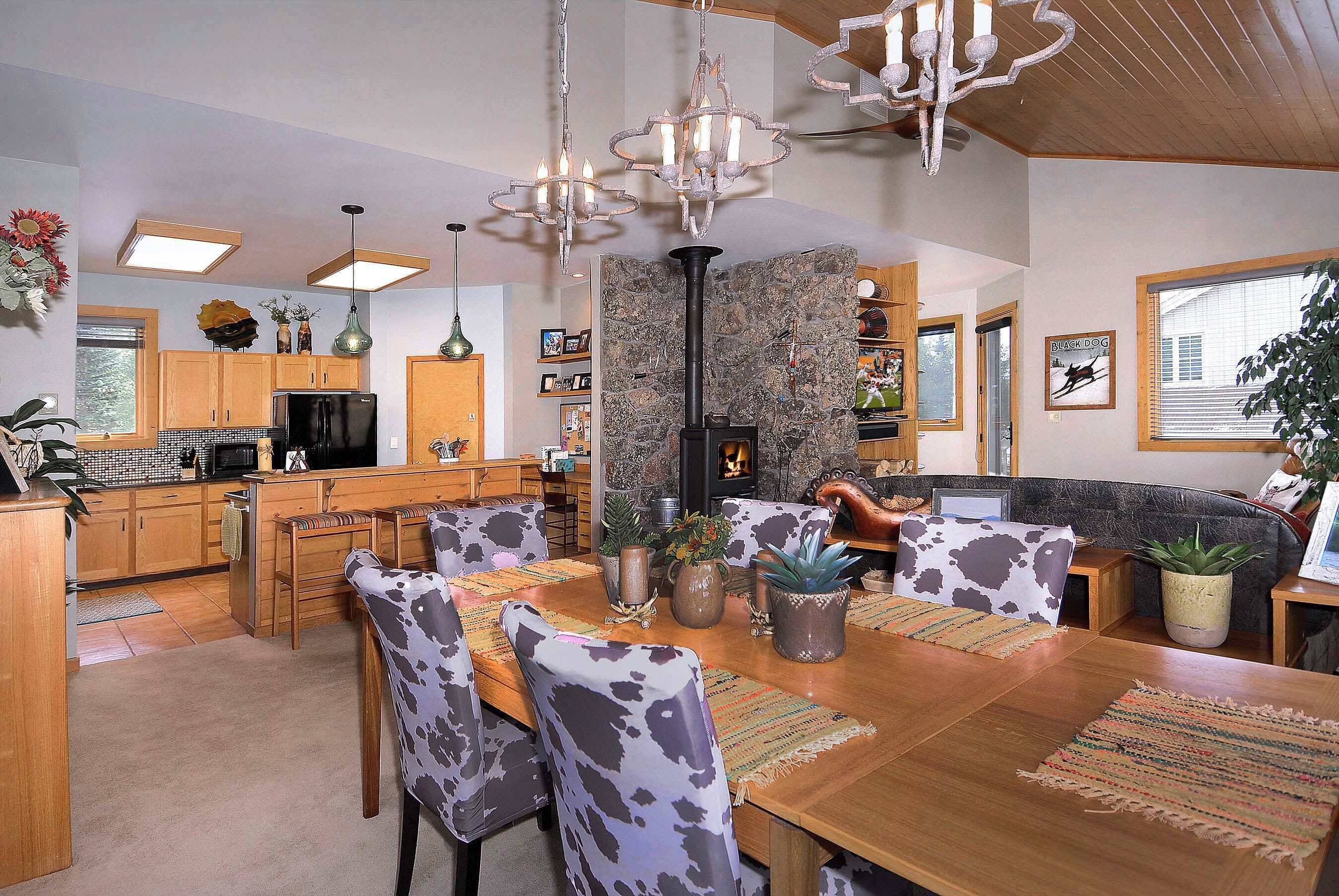 A dining area with a stone wall, wooden furniture, and a television.
