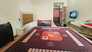 Een hotelkamer met een bed, een bureau, een televisie en een tafel met een spelbord.