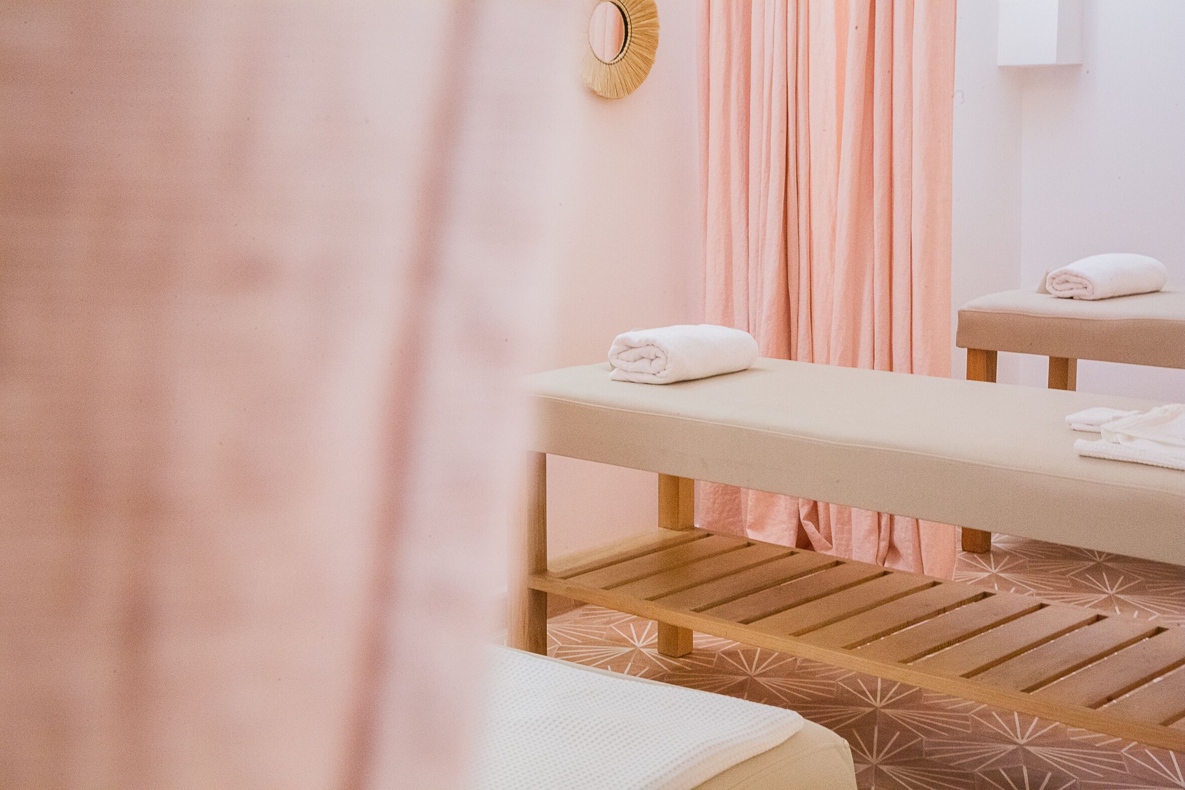 Une salle de spa équipée d’une table de massage, d’un banc et d’une serviette posée sur le banc.