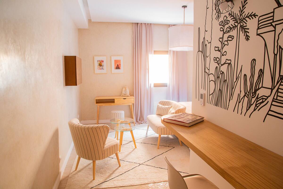 Una sala de estar moderna con un sofá, sillones, una mesa de centro y un escritorio de madera.